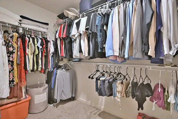 a view of walk in closet with clothes and shoes