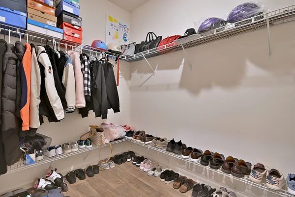 a view of walk in closet with clothes and shoes