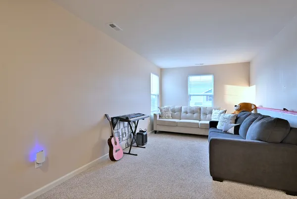 a living room with furniture and a gym machine