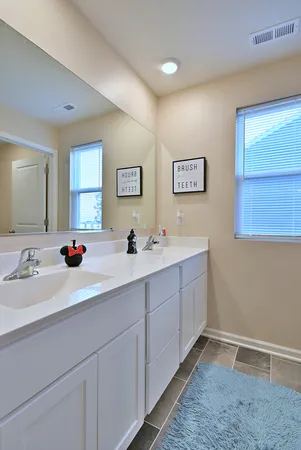 a bathroom with double sink and a mirror