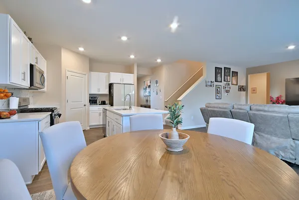 a living room with furniture kitchen and a wooden floor