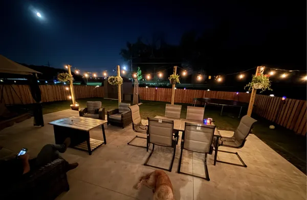 a outdoor space with lots of tables a chairs and a fireplace