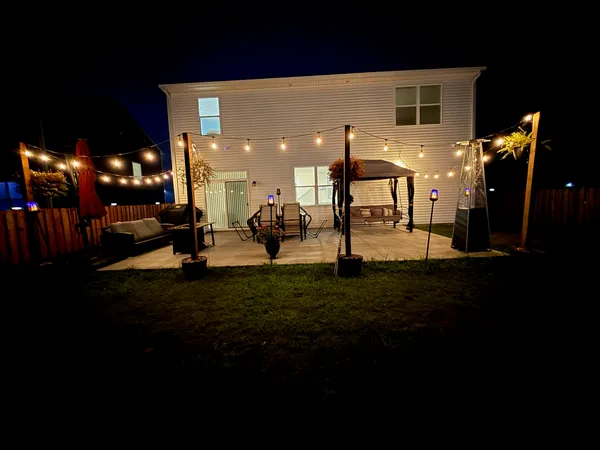 a group of people sitting in back yard of a building