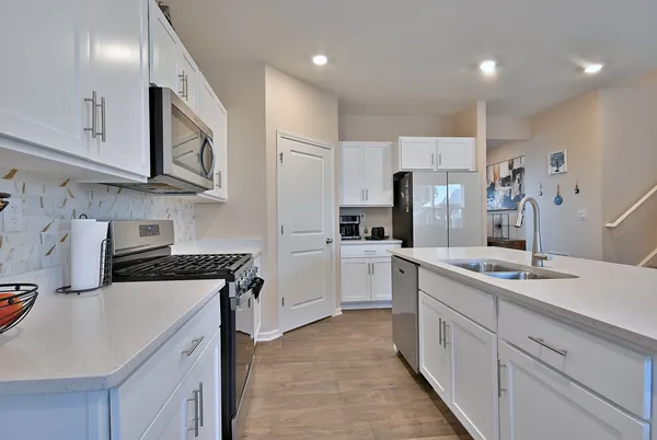 a kitchen with white cabinets sink and stainless steel appliances