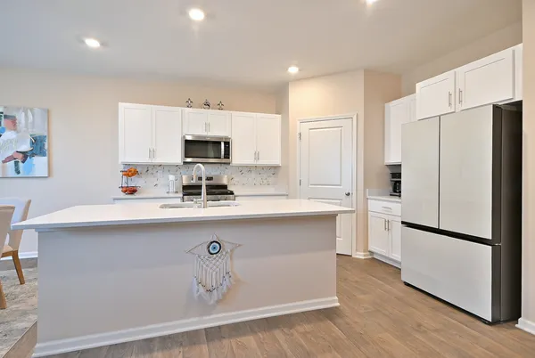 a kitchen with stainless steel appliances a refrigerator sink and microwave