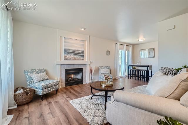 8234 Linderman Road Peyton, CO 80831 - Photo 3 of 24 Living room with hardwood / wood-style floors and a fireplace