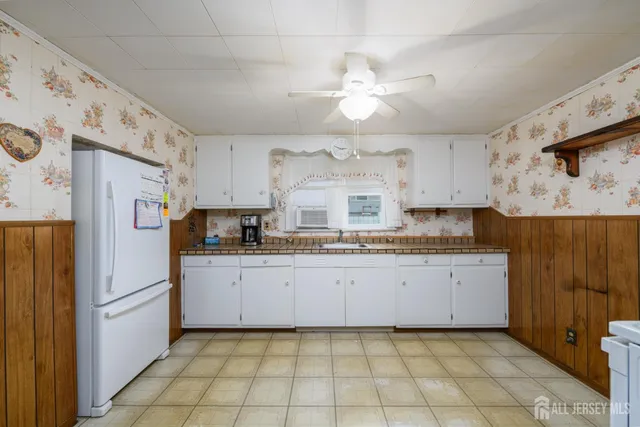 a kitchen with granite countertop a refrigerator and a sink