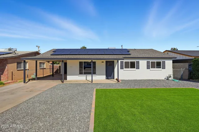 a front view of a house with a garden and yard