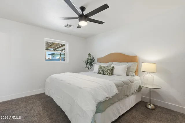 a bedroom with a bed and a painting on the wall