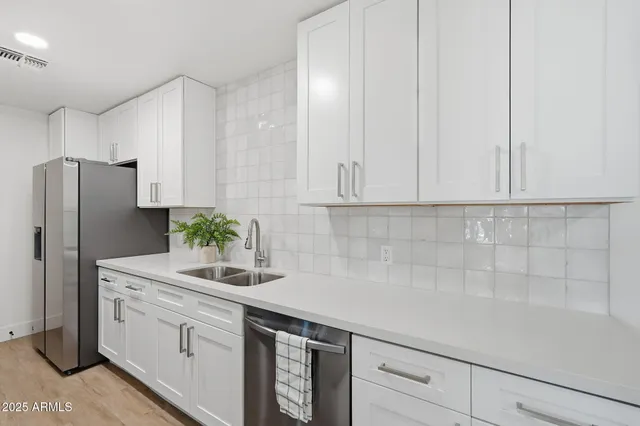 a kitchen with stainless steel appliances white cabinets and a refrigerator