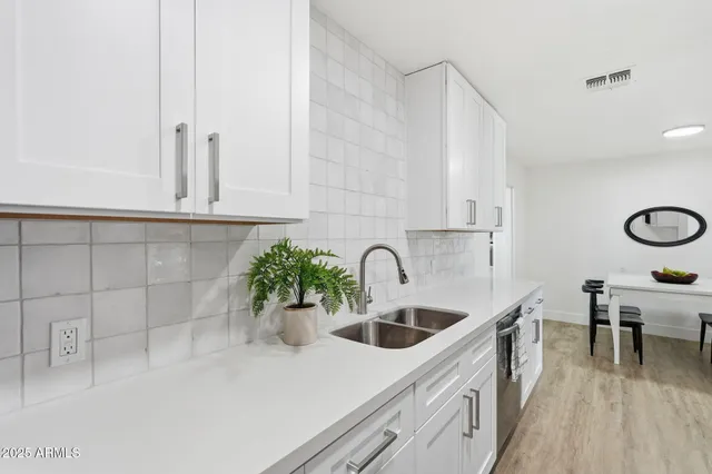a kitchen with a sink and white cabinets