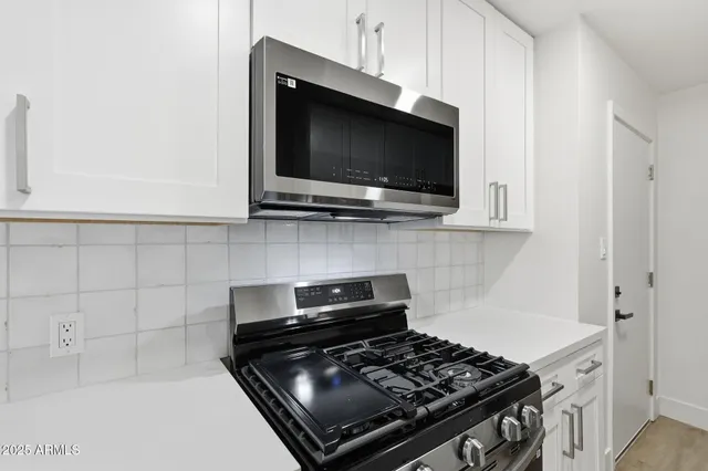 a kitchen with stainless steel appliances a stove a microwave and cabinets