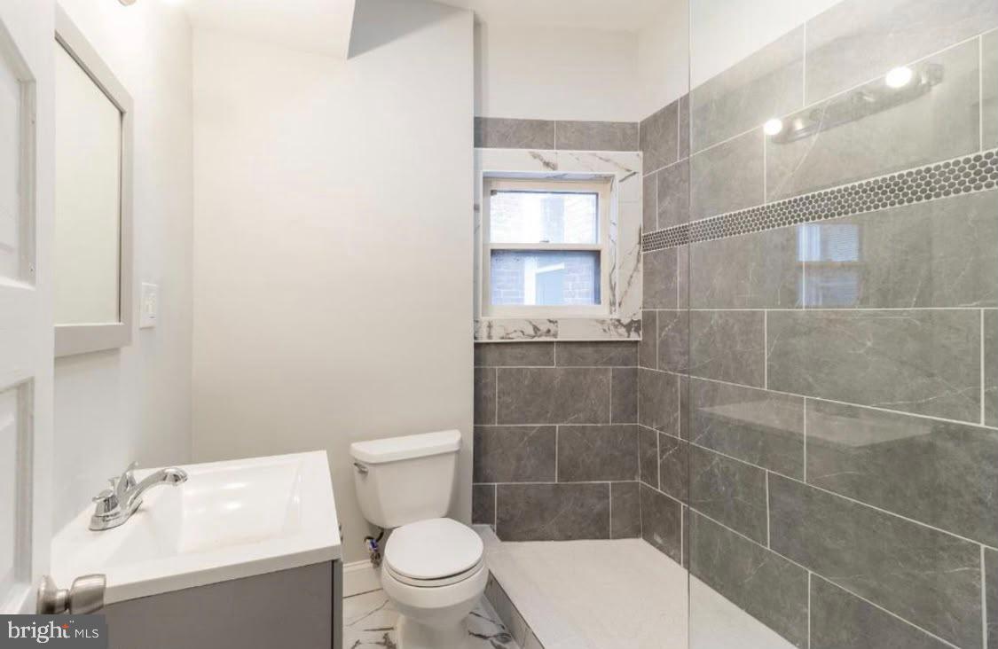 1626 Appleton Street Baltimore, MD 21217 - Photo 4 of 18 a bathroom with a toilet a sink and a shower
