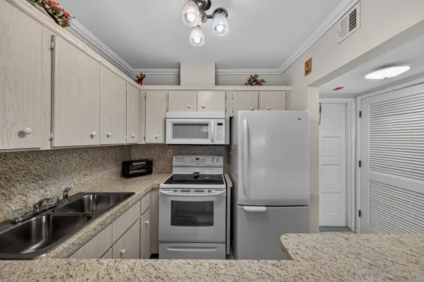 a kitchen with stainless steel appliances granite countertop a refrigerator sink and stove