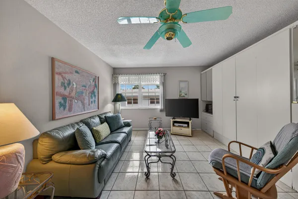 a living room with furniture a couch and a ceiling fan