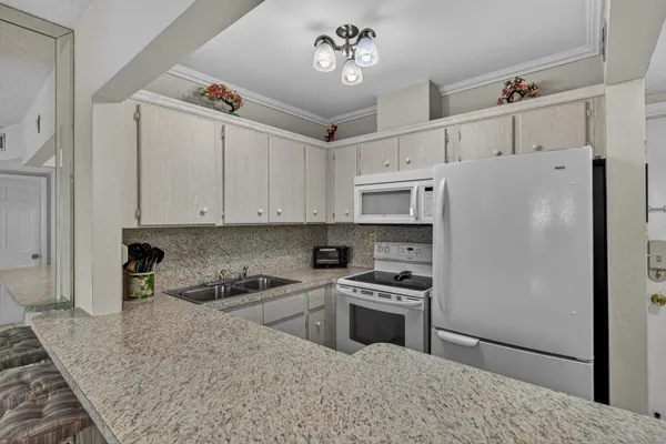 a kitchen with stainless steel appliances granite countertop a refrigerator sink and stove