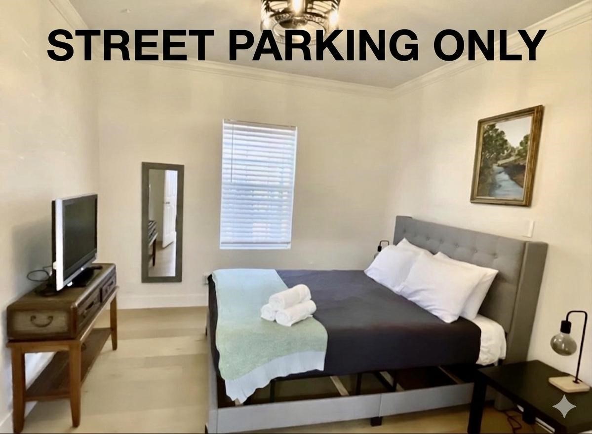 301 Tabor Street Houston, TX 77009 - Photo 9 of 14 a bedroom with a bed a couch and a flat tv screen on a dresser