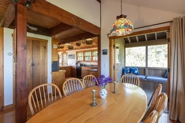 a view of a dining room with furniture a chandelier and large windows