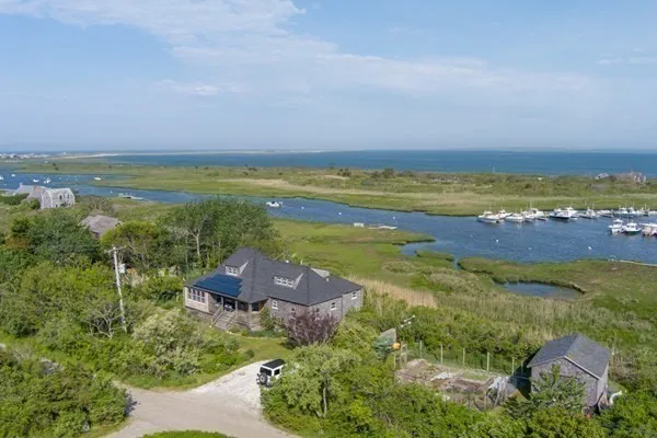 an aerial view of ocean and residential houses with outdoor space