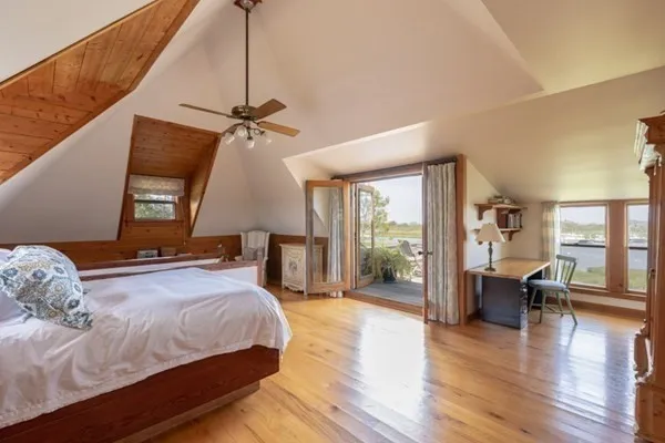 a bedroom with a balcony a bed and wooden floor