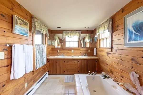 a bathroom with a tub sink and mirror