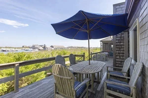 a view of deck with furniture and umbrella