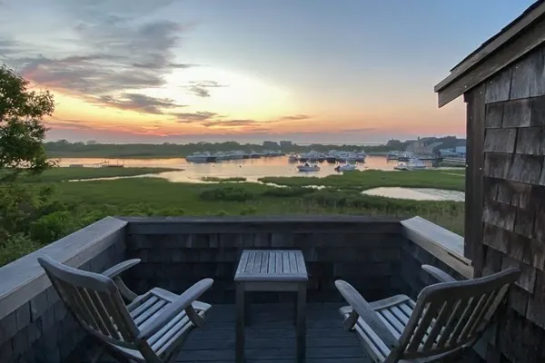 a view of a roof deck with couches and wooden floor