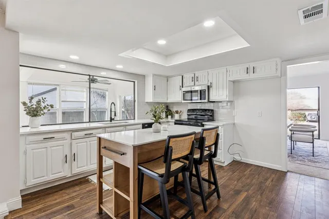 a kitchen with a table chairs refrigerator and cabinets