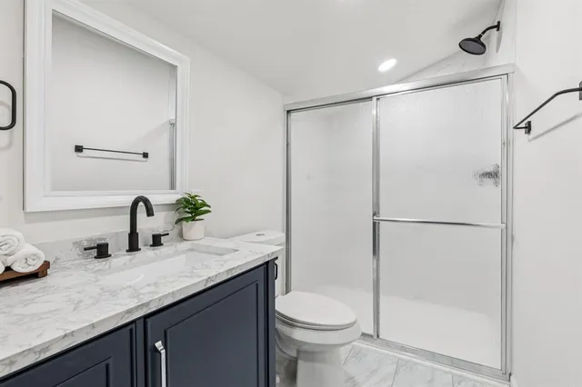 a bathroom with a granite countertop sink toilet and shower