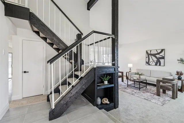 a living room with couches and stairs with wooden floor
