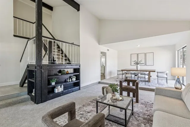 a living room with furniture and a dining table with wooden floor