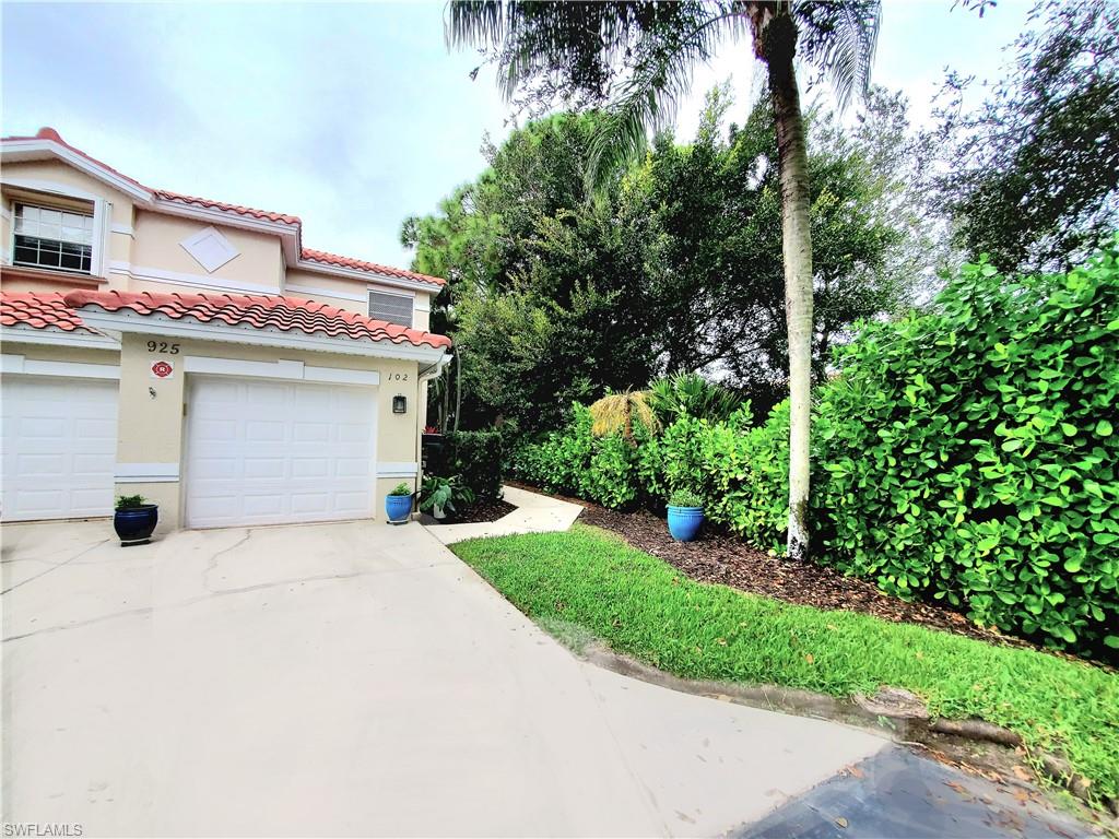 925 Eastham Way, Unit J102 Naples, FL 34104 - Photo 11 of 13 a view of a house with a yard and potted plants