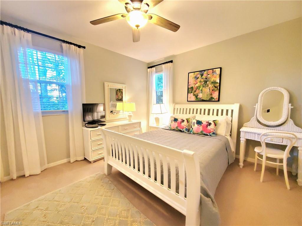 925 Eastham Way, Unit J102 Naples, FL 34104 - Photo 8 of 13 a bedroom with furniture and a large window