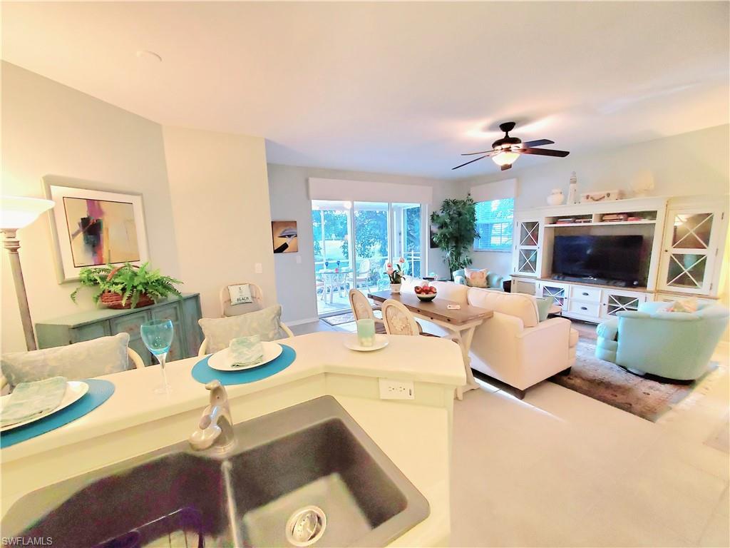 925 Eastham Way, Unit J102 Naples, FL 34104 - Photo 10 of 13 a living room with furniture and a flat screen tv