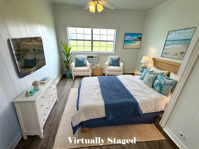 a bedroom with a bed and a flat tv screen on dresser