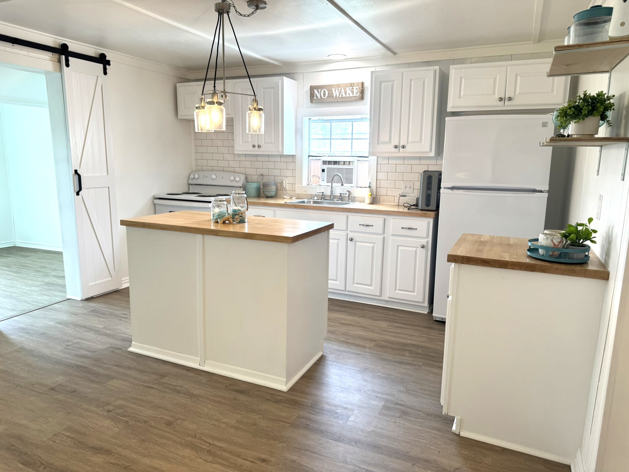 302 2nd Street Palacios, TX 77465 - Photo 18 of 45 a kitchen with refrigerator cabinets and wooden floor