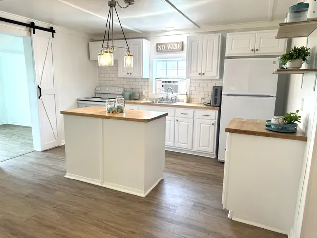 a kitchen with refrigerator cabinets and wooden floor