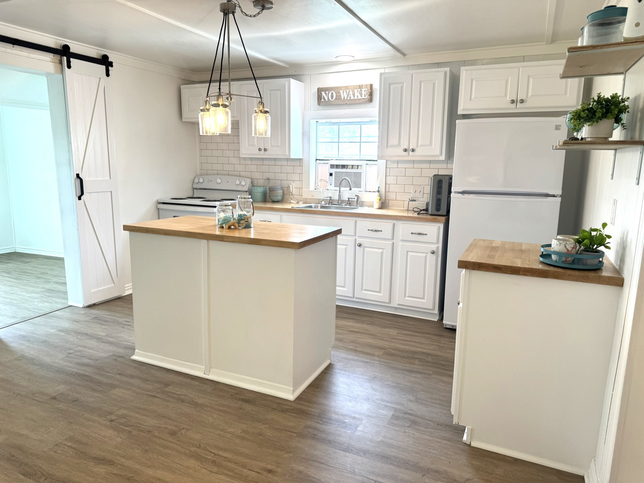 302 2nd Street Palacios, TX 77465 - Photo 18 of 45 a kitchen with refrigerator cabinets and wooden floor