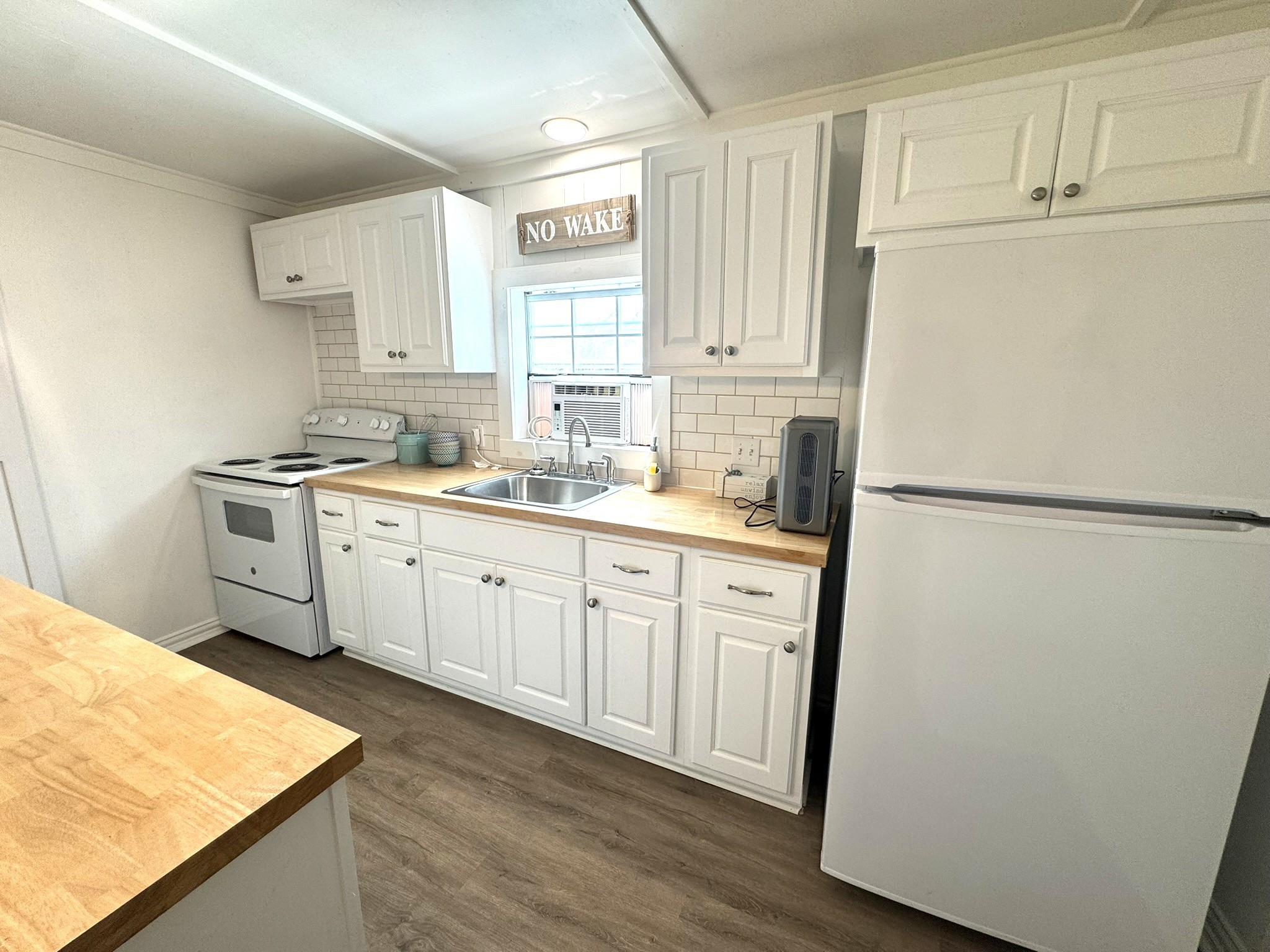 302 2nd Street Palacios, TX 77465 - Photo 19 of 45 a kitchen with a refrigerator sink stove and cabinets