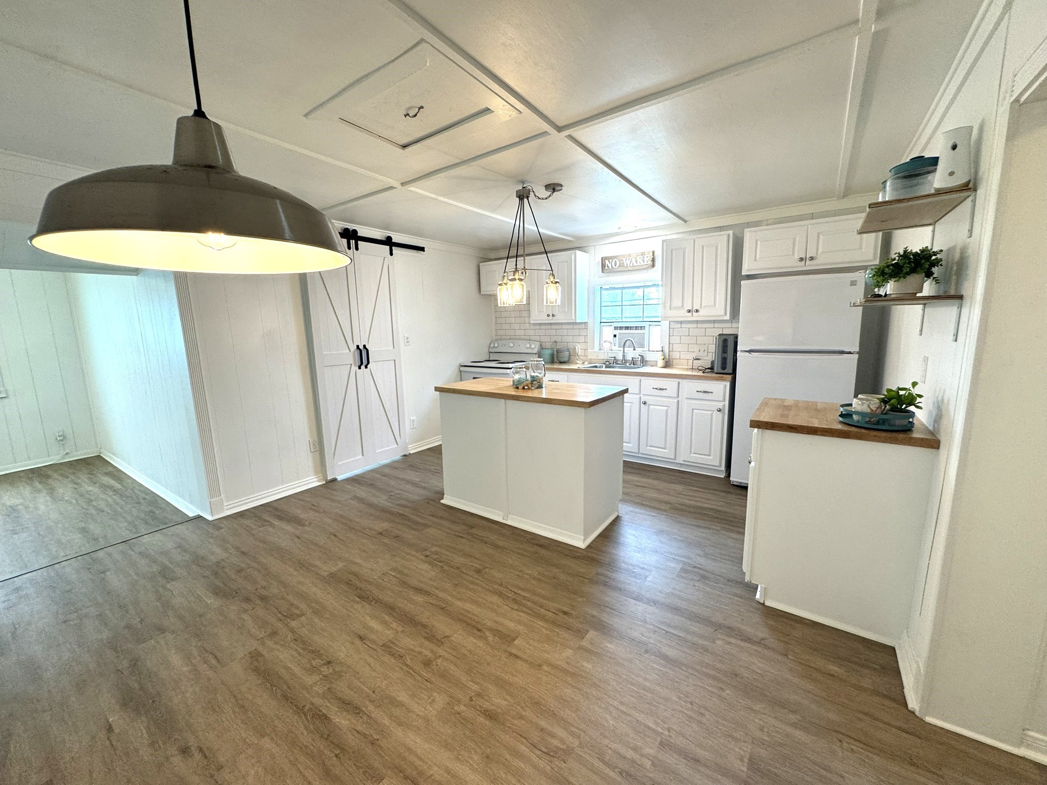 302 2nd Street Palacios, TX 77465 - Photo 24 of 45 a kitchen with stainless steel appliances granite countertop a refrigerator a sink dishwasher a stove and white cabinets with wooden floor
