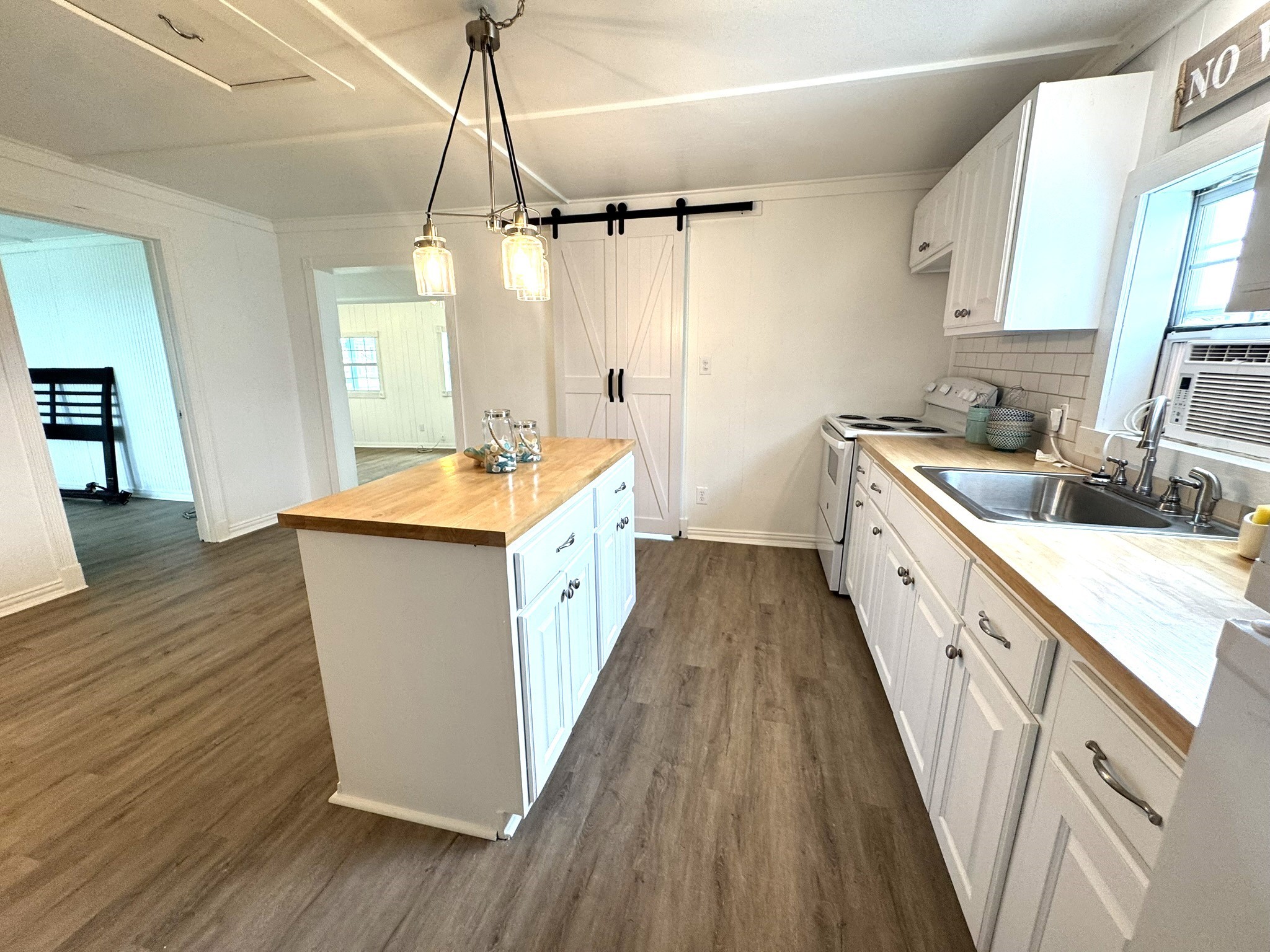 302 2nd Street Palacios, TX 77465 - Photo 26 of 45 a large kitchen with a sink and wooden floor