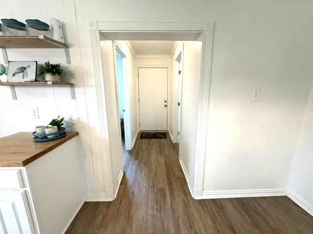 a view of a hallway with wooden floor and staircase
