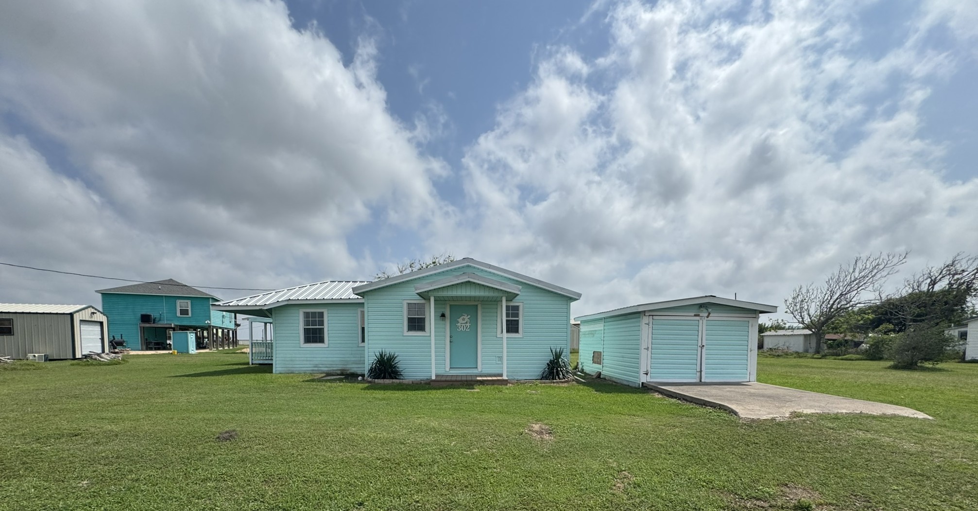 302 2nd Street Palacios, TX 77465 - Photo 3 of 45 a front view of a house with a garden and yard