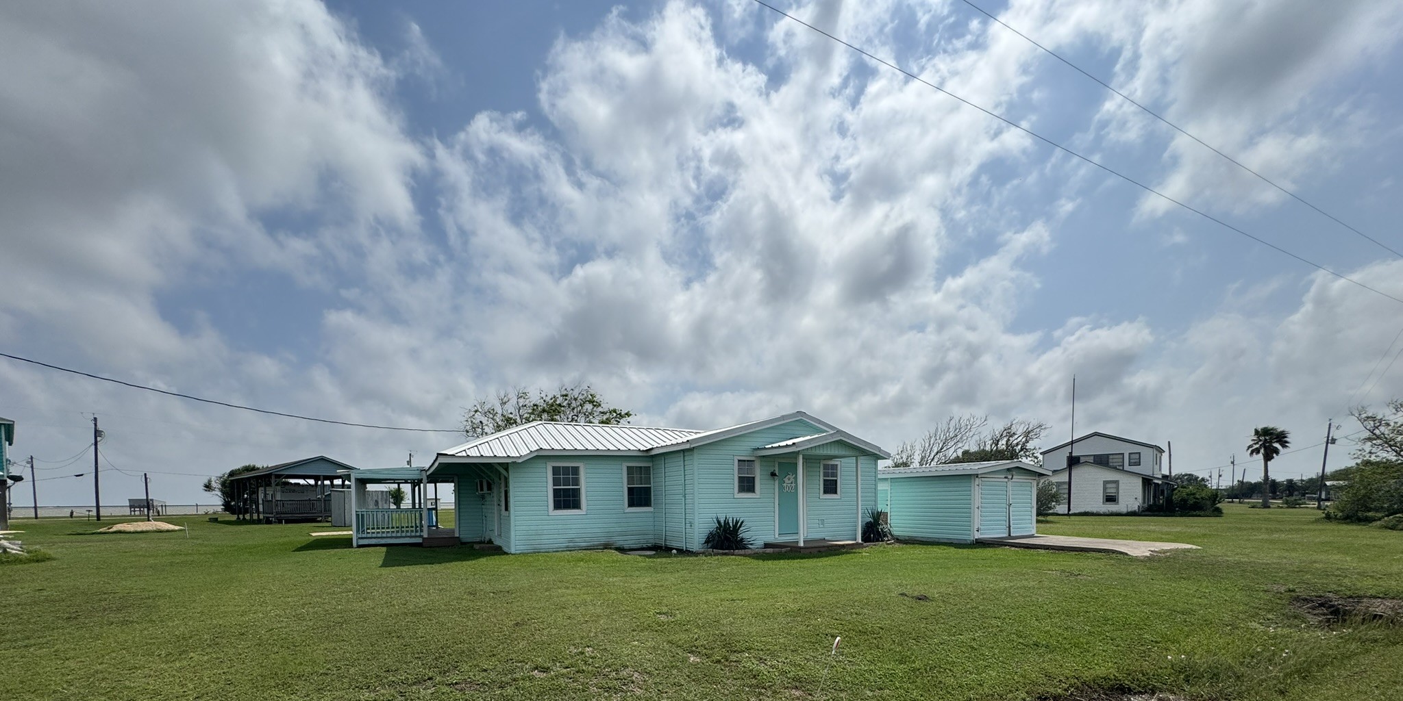 302 2nd Street Palacios, TX 77465 - Photo 5 of 45 a view of a house with a big yard and large trees