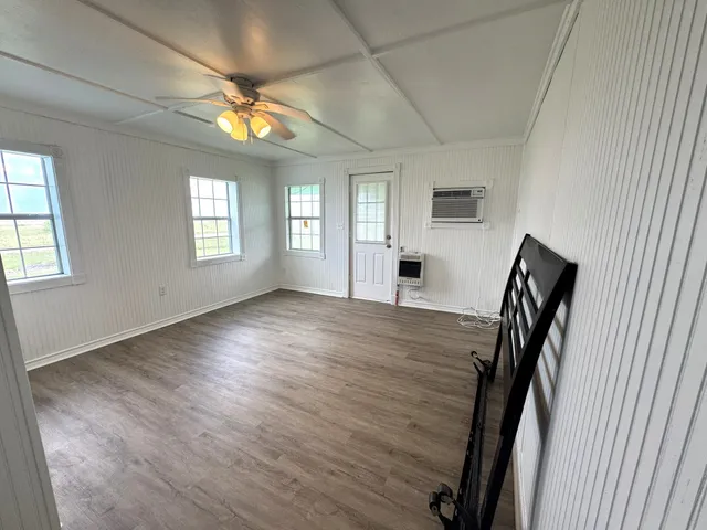 a view of empty room with window and wooden floor