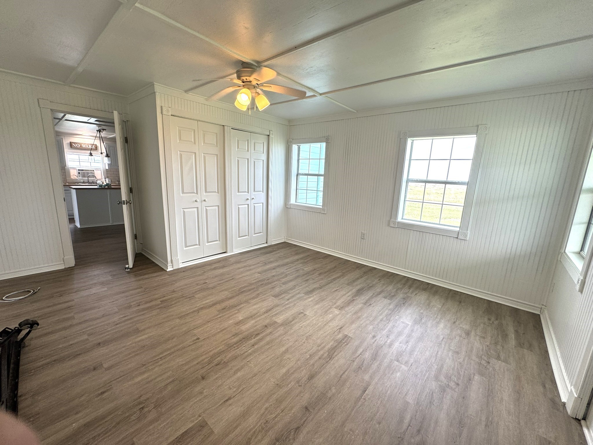 302 2nd Street Palacios, TX 77465 - Photo 9 of 45 an empty room with wooden floor and windows
