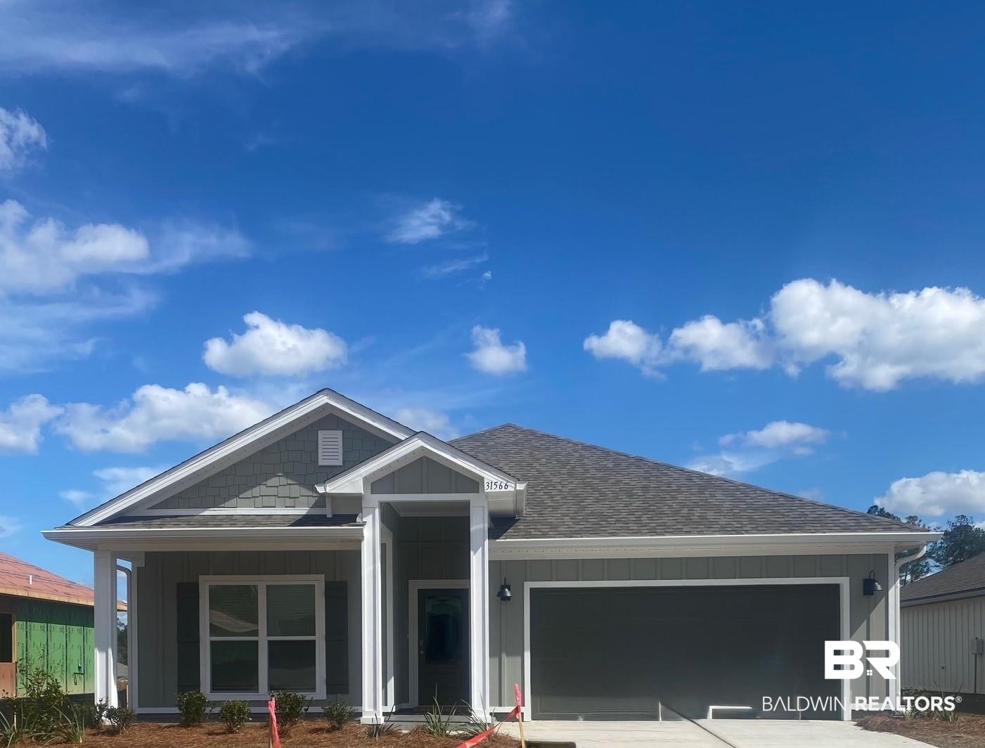 31566 Lyon Road Daphne, AL 36527 - Photo 1 of 35 View of front facade with board and batten siding, an attached garage, a shingled roof, and driveway