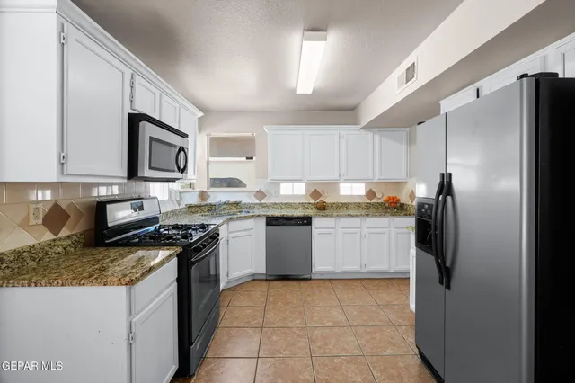 a kitchen with a refrigerator sink and cabinets