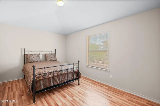 a bedroom with a bed window and wooden floor