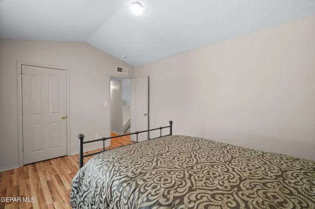 a bedroom with a bed and a painting on the wall